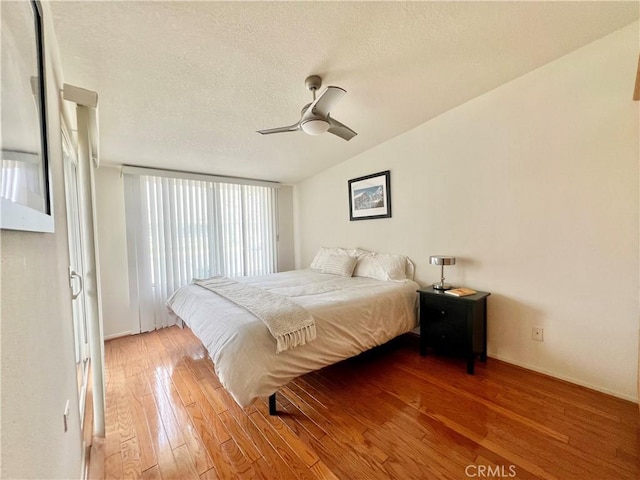 13721 El Dorado Dr Unit M3-K, Seal Beach, CA 90740 - bedroom with wood-type flooring, vaulted ceiling, a textured ceiling, and ceiling fan
