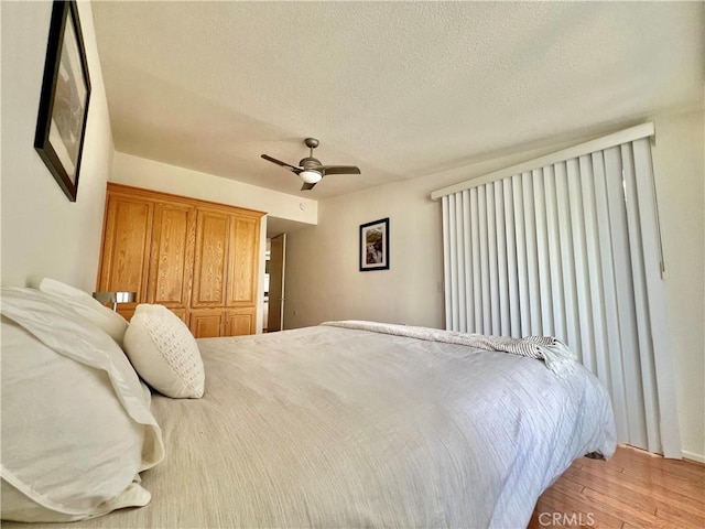 13721 El Dorado Dr Unit M3-K, Seal Beach, CA 90740 - bedroom with light wood-type flooring, a textured ceiling, and a ceiling fan