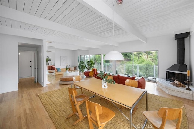 3102 Durand Dr, Los Angeles, CA 90068 - dining space with beamed ceiling, a wood stove, plenty of natural light, and light wood finished floors