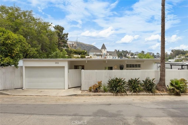 3102 Durand Dr, Los Angeles, CA 90068 - view of front facade featuring a fenced front yard, a garage, and a mountain view