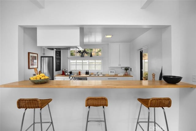 3102 Durand Dr, Los Angeles, CA 90068 - kitchen featuring freestanding refrigerator, a kitchen breakfast bar, a sink, and white cabinets