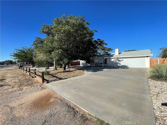12787 Algonquin Rd, Apple Valley, CA 92308 - view of front of home featuring driveway, an attached garage, and a chimney
