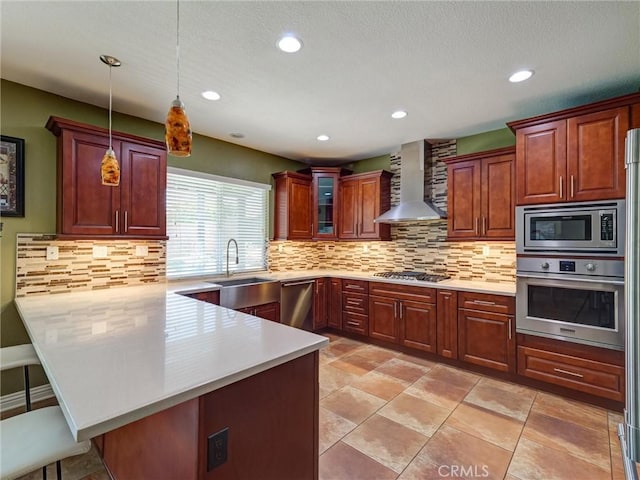 8242 Daisy Ln, Riverside, CA 92508 - kitchen featuring wall chimney range hood, appliances with stainless steel finishes, a sink, a peninsula, and a kitchen breakfast bar