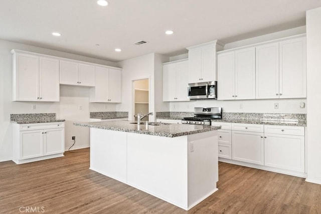 14226 Sonoma Ct, Beaumont, CA 92223 - kitchen featuring appliances with stainless steel finishes, a sink, wood finished floors, a kitchen island with sink, and recessed lighting