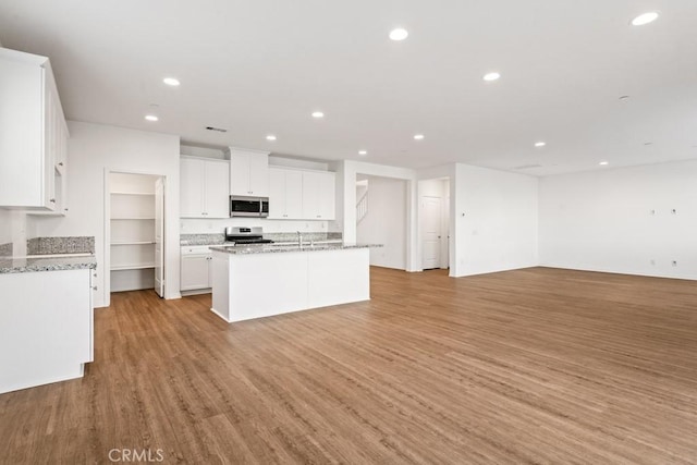 14226 Sonoma Ct, Beaumont, CA 92223 - kitchen with stainless steel appliances, open floor plan, white cabinetry, recessed lighting, and a sink