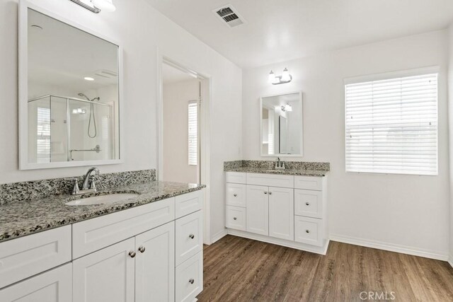 14226 Sonoma Ct, Beaumont, CA 92223 - bathroom featuring healthy amount of natural light, a stall shower, wood finished floors, and baseboards
