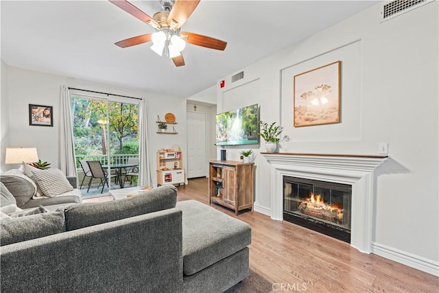 23411 Abbey Glen Pl Unit 41, Valencia, CA 91354 - living room featuring wood finished floors, a ceiling fan, a glass covered fireplace, and baseboards