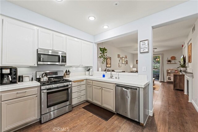 23411 Abbey Glen Pl Unit 41, Valencia, CA 91354 - kitchen with appliances with stainless steel finishes, tile counters, a sink, recessed lighting, and dark wood-style flooring