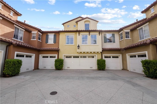 23411 Abbey Glen Pl Unit 41, Valencia, CA 91354 - view of front facade with an attached garage, a tile roof, and stucco siding