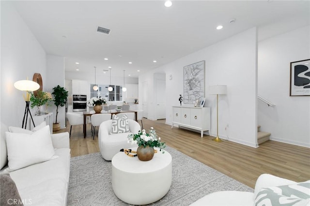 1075 Cadence, Irvine, CA 92618 - living room featuring light wood finished floors, stairway, and recessed lighting