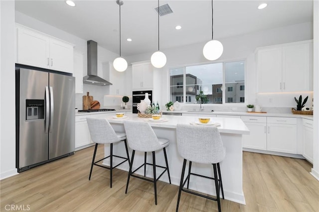 1075 Cadence, Irvine, CA 92618 - kitchen with stainless steel fridge, wall chimney range hood, a kitchen island, gas cooktop, and white cabinets