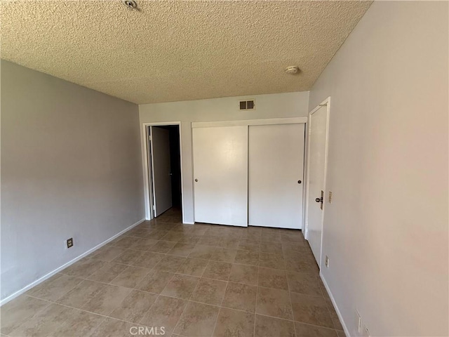 450 E 4th St Unit 207, Santa Ana, CA 92701 - unfurnished bedroom featuring a textured ceiling, a closet, tile patterned floors, and baseboards