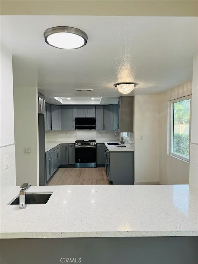 1202 Longview Dr, Diamond Bar, CA 91765 - kitchen featuring stainless steel range with gas stovetop, exhaust hood, gray cabinetry, a sink, and backsplash