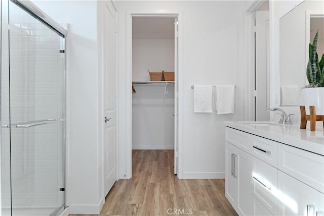 3260 Garnet Ln, Lancaster, CA 93535 - full bathroom with a stall shower, wood finished floors, vanity, and a spacious closet