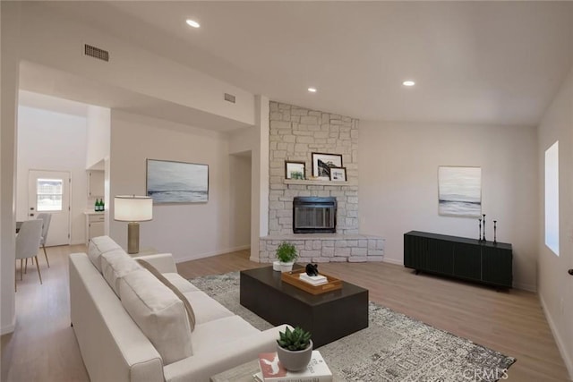 16754 Pauhaska Rd, Apple Valley, CA 92307 - living room with light wood-style floors, a stone fireplace, baseboards, vaulted ceiling, and recessed lighting