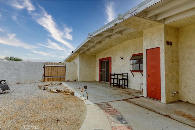 16811 Via Quedo, Desert Hot Springs, CA 92240 - view of exterior entry with a gate, stucco siding, and a patio area