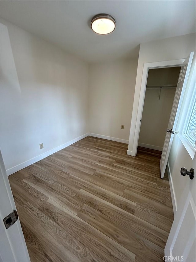 2033 W Burnett St, Long Beach, CA 90810 - unfurnished bedroom with wood finished floors, a closet, and baseboards