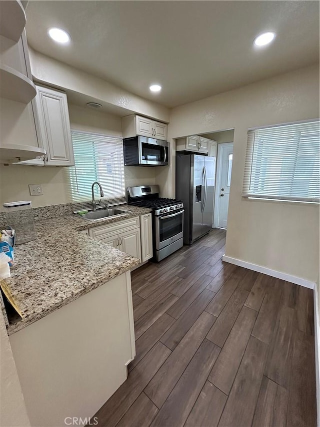 2033 W Burnett St, Long Beach, CA 90810 - kitchen featuring appliances with stainless steel finishes, open shelves, a sink, dark wood finished floors, and white cabinetry