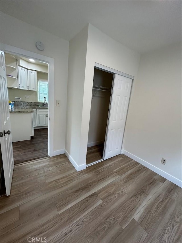2033 W Burnett St, Long Beach, CA 90810 - unfurnished bedroom featuring wood finished floors, a closet, and baseboards