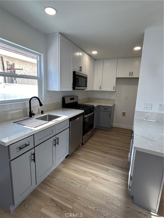 2033 W Burnett St, Long Beach, CA 90810 - kitchen featuring stainless steel appliances, a sink, gray cabinetry, light wood-style flooring, and recessed lighting
