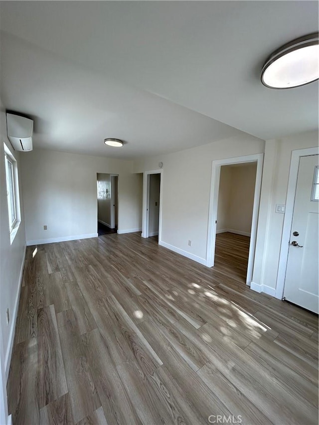 2033 W Burnett St, Long Beach, CA 90810 - spare room featuring a wall mounted air conditioner, wood finished floors, and baseboards
