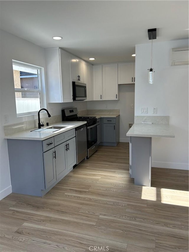 2033 W Burnett St, Long Beach, CA 90810 - kitchen featuring stainless steel appliances, baseboards, a wall mounted AC, a sink, and recessed lighting