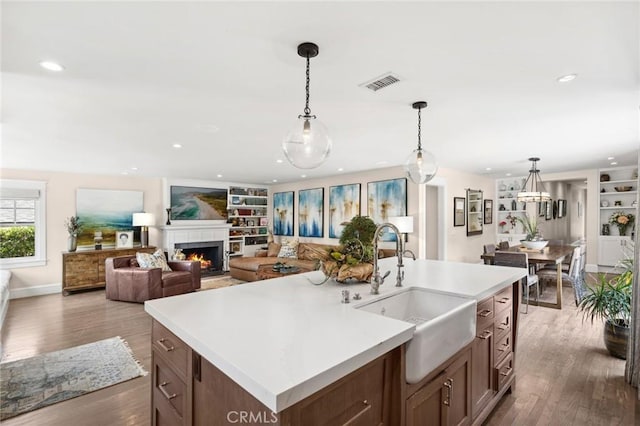620 Brooks St, Laguna Beach, CA 92651 - kitchen with a sink, a warm lit fireplace, wood finished floors, light countertops, and recessed lighting