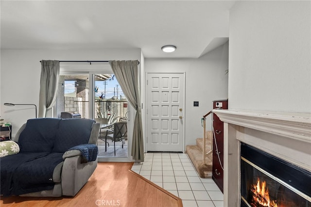 21817 Figueroa St Unit 5, Carson, CA 90745 - foyer featuring a glass covered fireplace, light wood finished floors, and stairway