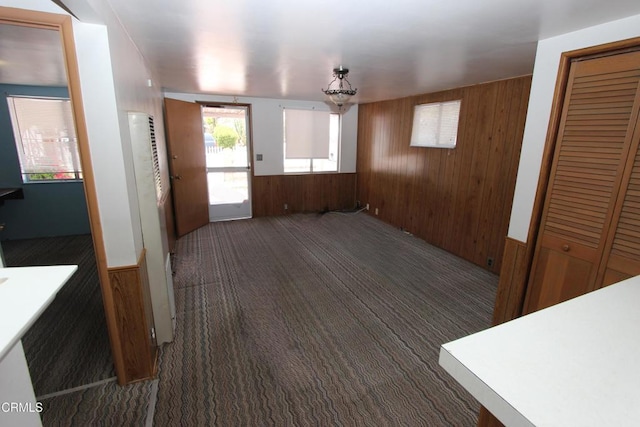 5021 Alvarado St, Carpinteria, CA 93013 - unfurnished dining area with wood walls, a heating unit, and carpet floors