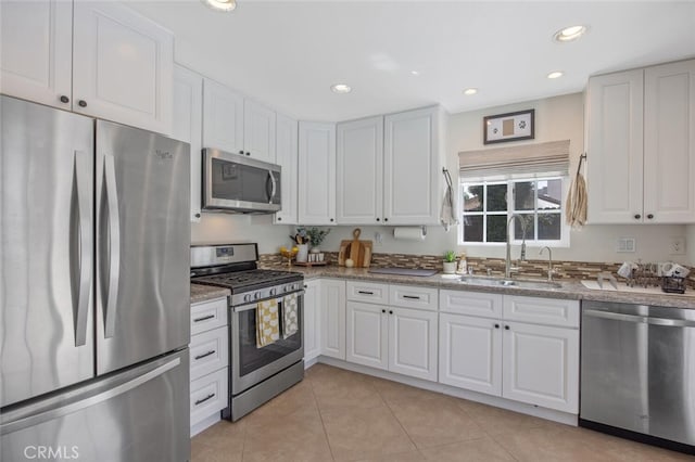 27702 Quincy St, Castaic, CA 91384 - kitchen with appliances with stainless steel finishes, a sink, white cabinets, light tile patterned floors, and recessed lighting