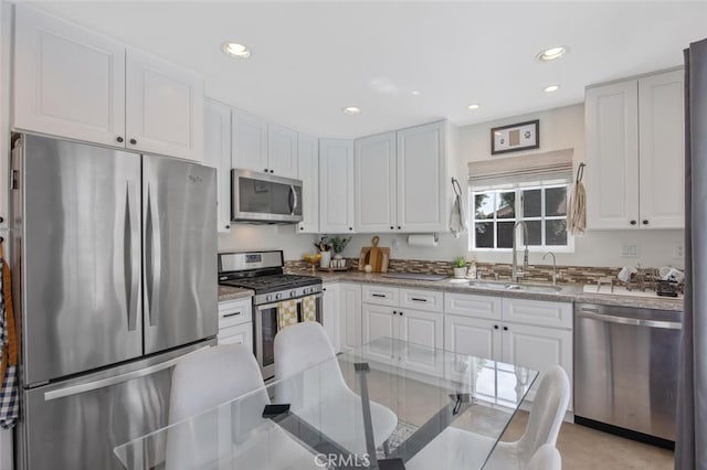 27702 Quincy St, Castaic, CA 91384 - kitchen featuring appliances with stainless steel finishes, a sink, white cabinets, recessed lighting, and light stone counters