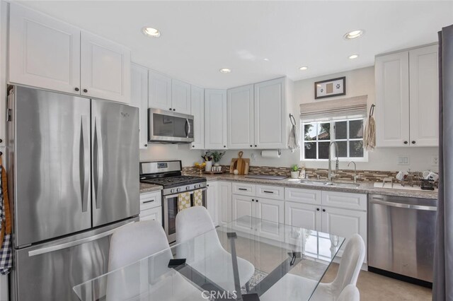 27702 Quincy St, Castaic, CA 91384 - kitchen featuring appliances with stainless steel finishes, a sink, white cabinetry, recessed lighting, and light stone countertops