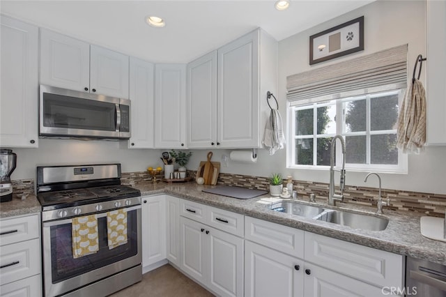 27702 Quincy St, Castaic, CA 91384 - kitchen featuring appliances with stainless steel finishes, a sink, white cabinetry, recessed lighting, and light stone countertops