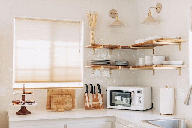960 Butte Ave, Big Bear City, CA 92314 - kitchen with white microwave, a sink, backsplash, and open shelves