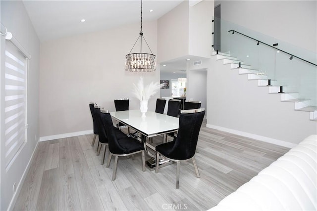 10670 Deering Ave, Chatsworth, CA 91311 - dining room with stairway, a chandelier, light wood-type flooring, baseboards, and high vaulted ceiling