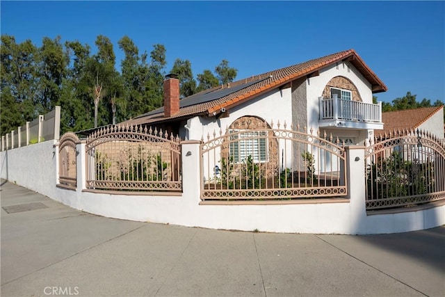 10670 Deering Ave, Chatsworth, CA 91311 - view of front of house with a gate, a chimney, a balcony, and a fenced front yard