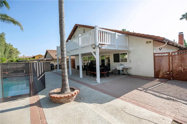 10670 Deering Ave, Chatsworth, CA 91311 - rear view of house featuring a patio, stucco siding, and a gate