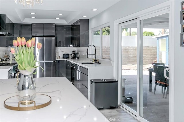 10670 Deering Ave, Chatsworth, CA 91311 - kitchen featuring freestanding refrigerator, a sink, modern cabinets, light stone counters, and dark cabinetry