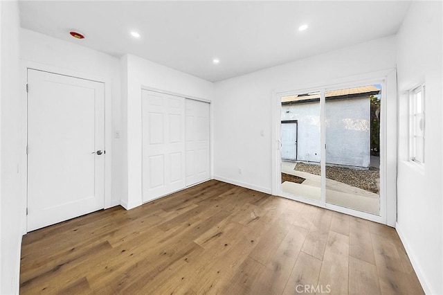 401 W Poplar St, Compton, CA 90220 - unfurnished bedroom featuring access to outside, wood-type flooring, recessed lighting, baseboards, and a closet