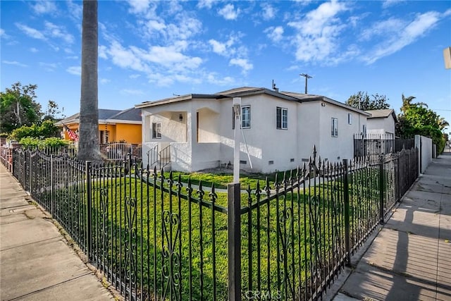 401 W Poplar St, Compton, CA 90220 - view of front of house with stucco siding, a fenced front yard, and crawl space