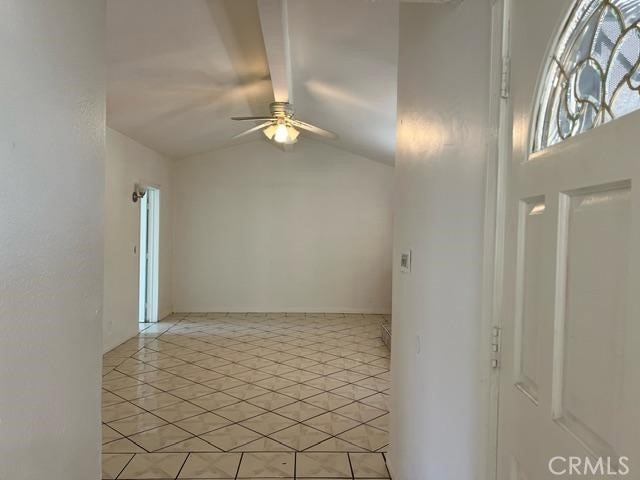 12760 Judd St, Pacoima, CA 91331 - spare room with a ceiling fan, lofted ceiling, and light tile patterned floors