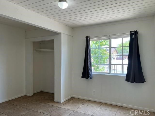 12760 Judd St, Pacoima, CA 91331 - unfurnished bedroom with a closet, light tile patterned floors, and baseboards