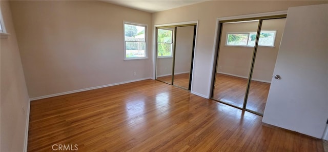 16718 Gledhill St, Northridge, CA 91343 - unfurnished bedroom featuring multiple windows, two closets, baseboards, and wood finished floors