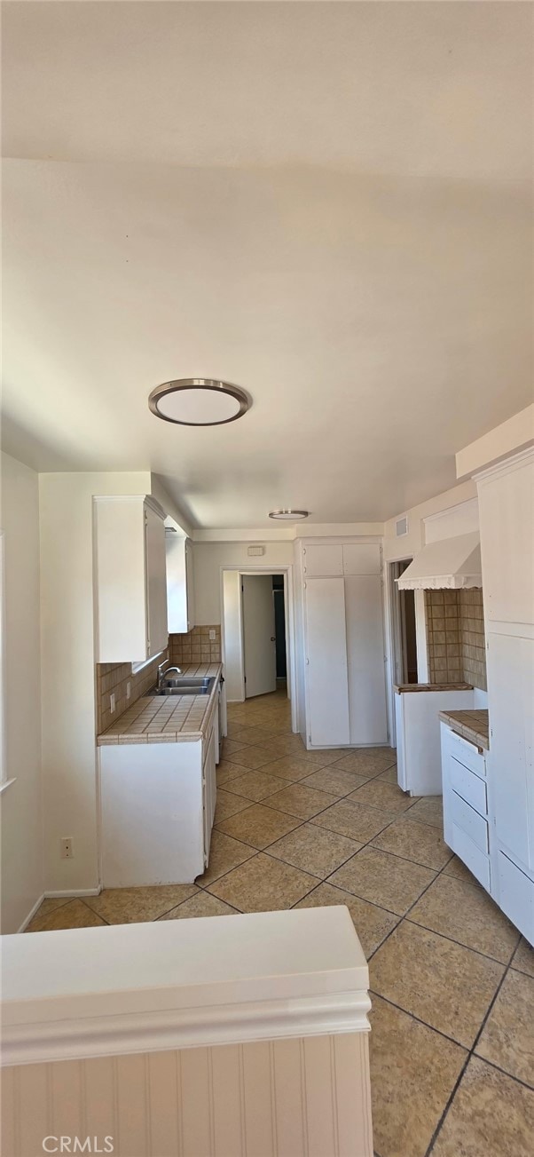 16718 Gledhill St, Northridge, CA 91343 - kitchen featuring tile countertops, tasteful backsplash, white cabinetry, and a sink
