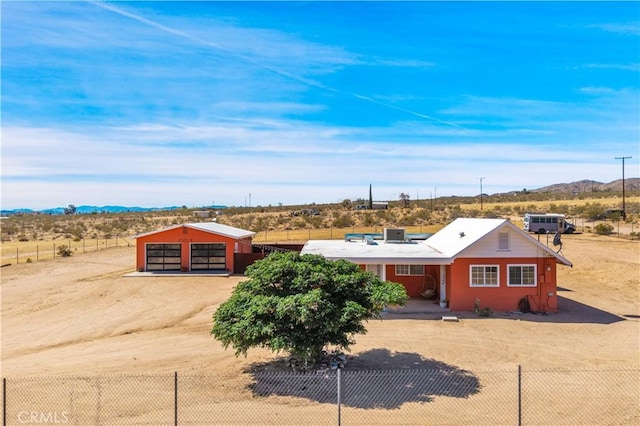 55850 Shannon Rd, Landers, CA 92285 - view of front facade with a mountain view, driveway, a detached garage, an outdoor structure, and a rural view