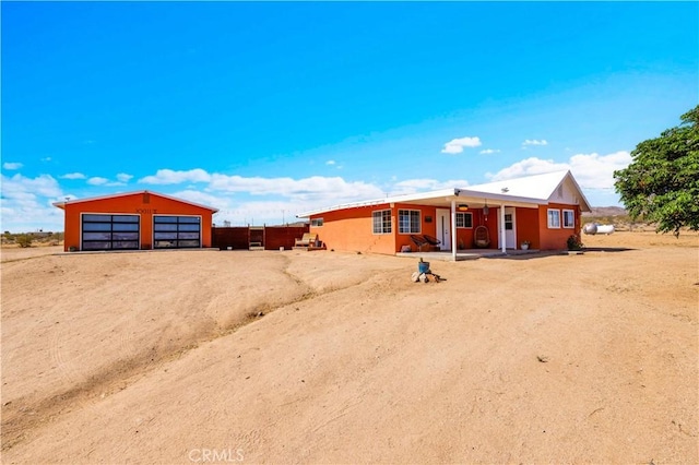 55850 Shannon Rd, Landers, CA 92285 - rear view of house featuring a detached garage, driveway, and an outbuilding
