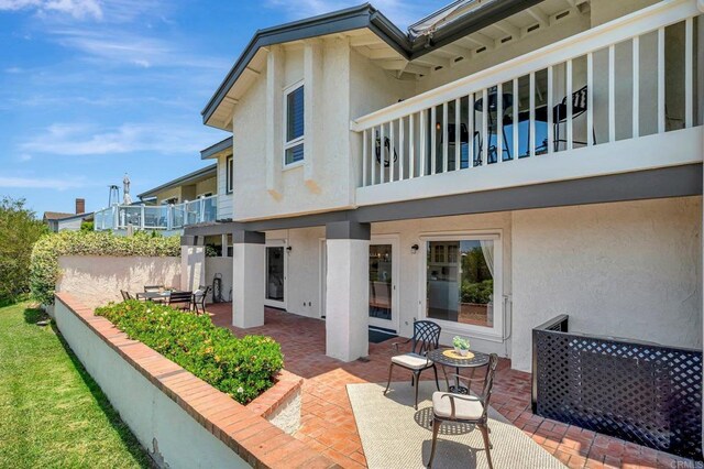 55 Jasmine Creek Dr, Corona Del Mar, CA 92625 - rear view of house featuring stucco siding, a balcony, and a patio
