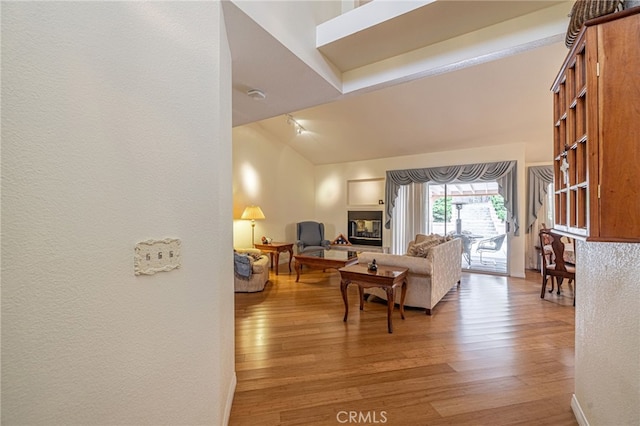 5340 Gardendale Ln, Palmdale, CA 93551 - living room featuring wood finished floors, vaulted ceiling, and a textured wall