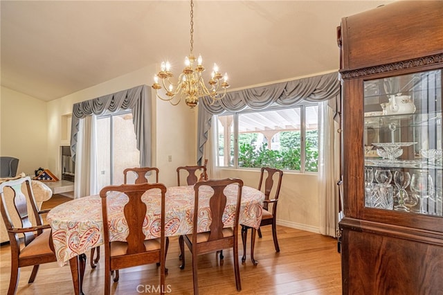 5340 Gardendale Ln, Palmdale, CA 93551 - dining room with vaulted ceiling, light wood-style floors, a chandelier, and baseboards