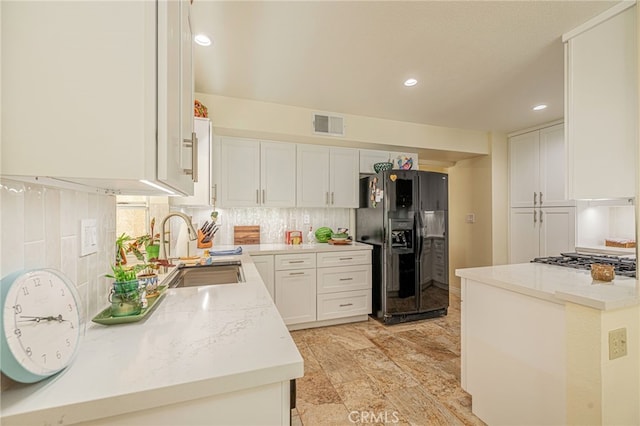 5340 Gardendale Ln, Palmdale, CA 93551 - kitchen featuring black refrigerator with ice dispenser, a sink, tasteful backsplash, stainless steel gas cooktop, and white cabinets